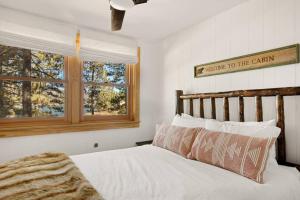 a bedroom with a bed with a wooden headboard and a window at Lakefront View Stunner in Big Bear Lake