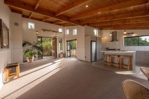 a large living room with a wooden ceiling at Tahana Villa - River View Retreat - 3 Bedroom in Oakura