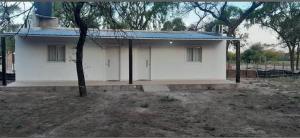 a small white house with a blue roof at Posada doña ilene in Quimilí