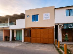 a house with orange garage doors on a street at La Casita Rooms - Habitaciones Coveñas in Coveñas