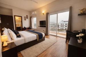a hotel room with a bed and a large window at The Amber Signature Vrindavan # A Luxury Apartment With #Lift# Garden # Parking# Ac Rooms# & Elegant interior # Located Inside- Omaxe Eternity Vrindavan in Vrindāvan