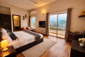 a hotel room with a bed and a large window at The Amber Signature Vrindavan # A Luxury Apartment With #Lift# Garden # Parking# Ac Rooms# & Elegant interior # Located Inside- Omaxe Eternity Vrindavan in Vrindāvan