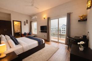 a bedroom with a large bed and a large window at The Amber Signature Vrindavan # A Luxury Apartment With #Lift# Garden # Parking# Ac Rooms# & Elegant interior # Located Inside- Omaxe Eternity Vrindavan in Vrindāvan