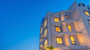 a tall white building with its lights on at Gangneung Basecamp Pension in Gangneung