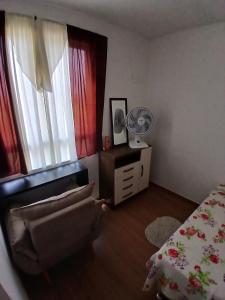 a bedroom with a bed and a chair and a window at Apartamento da Lagoa in Londrina +45 photos