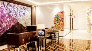 a lobby with paintings on the walls and tables at Hotel Indigo Singapore Katong by IHG in Singapore