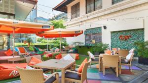 an outdoor patio with tables and chairs and umbrellas at Hotel Indigo Singapore Katong by IHG in Singapore