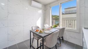 a dining room with a table and chairs and a window at Gapyeong Ciere Poolvilla in Gapyeong
