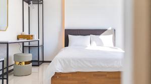 a bedroom with a bed with white sheets and white pillows at Gapyeong Ciere Poolvilla in Gapyeong +1 photo