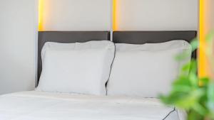 a bed with white sheets and two pillows at Gapyeong Ciere Poolvilla in Gapyeong
