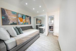 a bedroom with a couch and paintings on the wall at Beachfront Bliss at Isla Verde in San Juan