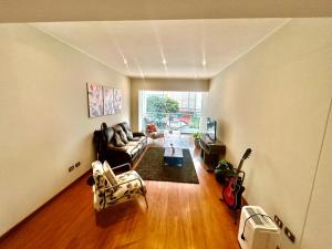 a living room with a couch and a guitar at Spacious Apartment in Miraflores in Lima