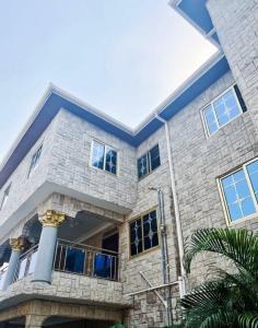 a large stone house with a blue roof at Fofana Luxury Suites in Sotuom
