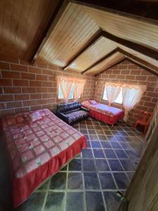 a room with two beds and a brick wall at Rancho buena vista in Mineral del Chico