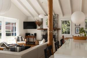 a living room with a couch and a fireplace at White Shell Cottage - Woodfire & Beachfront in Falmouth +27 photos