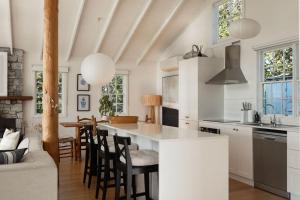 a kitchen with a large white island in a room at White Shell Cottage - Woodfire & Beachfront in Falmouth