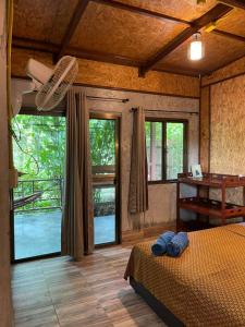 a bedroom with a bed and a desk and windows at Lok Mun Bungalows in Ko Yao Noi +72 photos