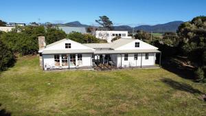 an aerial view of a white house with a large yard at White Shell Cottage - Woodfire & Beachfront in Falmouth