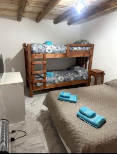 a bedroom with two bunk beds with blue towels at Hostel Luxfran in Uspallata