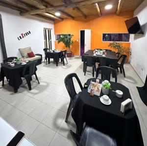 a restaurant with black tables and chairs and tablesearcher at Hostel Luxfran in Uspallata