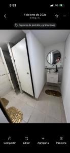 a picture of a bathroom with a door and a mirror at Hostel Luxfran in Uspallata