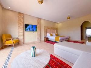 a bedroom with a bed and a living room at Igrane House - Resort & Spa in Aït Faska