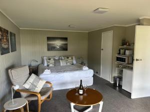 a bedroom with a bed and a table and chairs at The Pacific Room, Tapeka Point in Russell