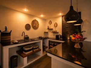 a kitchen with a counter with a bowl of fruit on it at Villa Jasmine by Anakara in Ubud