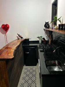 a kitchen with a sink and a counter top at Chalé Carvalho in Araucária