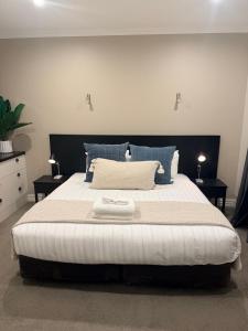 a bedroom with a large bed with blue pillows at Cardrona Mountain Villa in Cardrona +7 photos