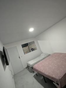 a bedroom with two beds and a tv in it at Residencial Scarparo in Iguape