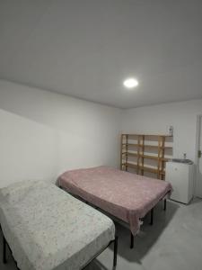 a room with two beds and a small refrigerator at Residencial Scarparo in Iguape