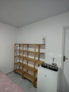 a room with a shelf and a stove in it at Residencial Scarparo in Iguape