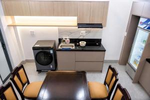 a kitchen with a stove and a table and chairs at BY Home in Hue