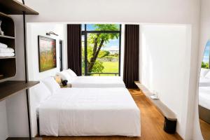 a hotel room with two beds and a window at BY Home in Hue