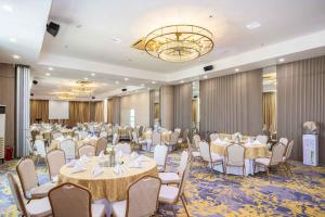 a banquet room with tables and chairs and a chandelier at Citi Park Hotel Cebu powered by Cocotel in Cebu City