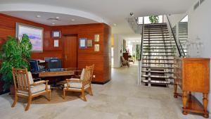 a living room with a table and chairs and a staircase at Meliá Cala d'Or Boutique Hotel in Cala d´Or