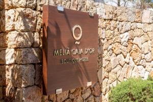 a sign for a miela camel day on a stone wall at Meliá Cala d'Or Boutique Hotel in Cala d´Or