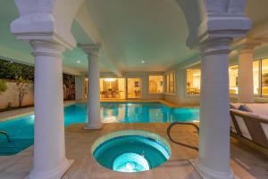 a large swimming pool with columns and a blue tub at 5-star Lanikai BEACHFRONT (5 bedrooms,sleeps 13) in Kailua