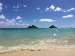 a beach with two islands in the ocean at 5-star Lanikai BEACHFRONT (5 bedrooms,sleeps 13) in Kailua