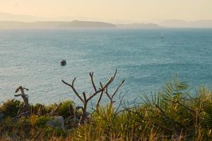 a view of the ocean with a boat in the water at Phu Yen Beachfront Fishing Village Homestay in Tuy Hoa