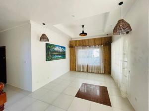 a living room with white walls and a large window at Peace And Cool Hotel in Siem Reap