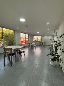 a room with tables and chairs and a potted plant at Tortugas Hotel in Carlos Casares