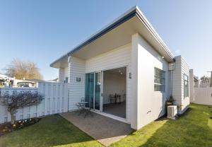 a white house with a large sliding glass door at Broadway Motel & Miro Court Villas in Matamata