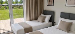 a bedroom with two beds and a large window at Ferienhaus Elbdeichblick 2 in Haselau
