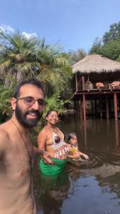 a man and a woman in the water with a baby at Casa da Arvore Experiencia com cafe da manha e ar condicionado in Santarém