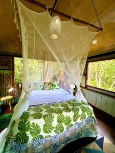 a bedroom with a bed with a mosquito net at Casa da Arvore Experiencia com cafe da manha e ar condicionado in Santarém +51 photos