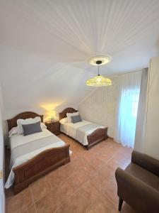 a bedroom with two beds and a chandelier at Casa Zoila in Porto do Son