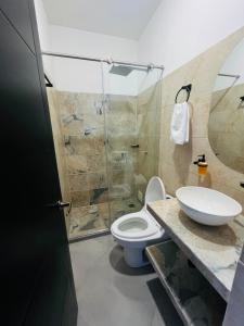 a bathroom with a toilet and a sink and a shower at BLUE DAYS Hotel Melgar in Melgar +11 photos