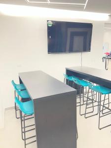 a conference room with two tables and blue chairs at BLUE DAYS Hotel Melgar in Melgar